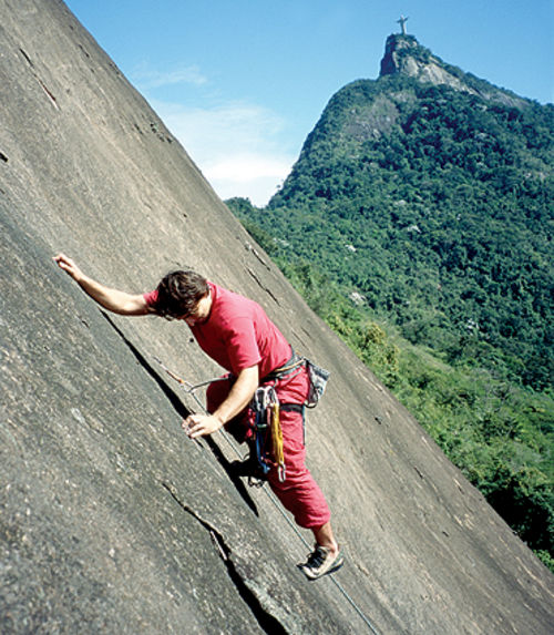 Silvio Neto na via <i>Trinta de Julho</i> (foto: Antonio Paulo Faria)” /><br />
Silvio Neto na via <i>Trinta de Julho</i> (foto: Antonio Paulo Faria)</div>
<p><b>Cidade mais próxima:</b> Rio de Janeiro</p>
<p><b>Tipo de pedra:</b> Granito – Gnaisse</p>
<p><b>Estilo predominante:</b> Aderência</p>
<p><b>Número de vias (aproximado):</b> 27</p>
<p><b>Divisão por grau das vias (aproximado):</b><br />Até V grau   12<br />Vsup à VIIc   12<br />VIIIa para cima   3</p>
<p><b>Vias de escalada:</b><br />A face norte possui sete vias, a mais freqüentada é a <i>Trinta de Julho</i> (4º Vsup E2), 200m, e a <i>UNICEC</i> (3º IIIsup E2), 250m. A mais difícil é a <i>Contos Inacabados</i> (5º VIIa E2), 130m.</p>
<p>Na face leste existem onze vias, e a mais freqüentada, provavelmente é a <i>Segredo do Abismo</i> (4º V E2), 240m. Os esticões são bem medidos, para corda de 50m. Caso contrário, as paradas ficam desconfortáveis, em grampos de 1/2 com olhal pequeno. A via mais dificil nesta face é a <i>Nervos de Aço</i> (5º VIIb E2), 250m.</p>
<p>A face sul conta com 4 vias, mais alguns projetos.</p>
<p>O Dona Marta é um festival de aderência, exceto o início da <i>Nervos de Aço</i>, bem vertical e quebradiço, em pedreira pouco sólida (já derrubaram uns blocos grandes por lá…) e a <i>Contos Inacabados</i>, com lances em agarras na parte final. Esta é mais vertical que as outras. Usam-se alguns móveis (<i>UNICEC</i>, <i>Solar</i>, <i>Nitroglicerina</i>, <i>Segredo do Abismo</i>) e a grampeação é boa.</p>
<p>Na face norte, logo abaixo do mirante, encontra-se a Falésia do Mirante Dona Marta, com 8 vias de IV a IXa, verticais e negativas, com agarras sólidas ou reforçadas com Sika. E um visual alucinante da Baía de Guanabara.</p>
<p><b>Comentários:</b><br />Existem favelas próximas ao Morro, e embora não se tenha registro de nenhum incidente, recomenda-se atenção e retorno da escalada ainda com a luz do dia.</p>
<p><b>Como chegar:</b><br />Face norte (acesso pelo Cosme Velho) – Suba até o final da Rua Efigênio Sales, que se localiza ao lado da Estação do bondinho do Corcovado. Se for de carro, deixe estacionado logo no início da rua, próximo à Estação do bondinho; é seguro e tem sempre alguém para tomar conta do carro. Se for de ônibus, existem várias linhas que levam até o Cosme Velho. No final da rua Efigênio Sales você irá encontrar um leito de rio seco, meio sujo. Suba em direção à montanha, sempre para a esquerda, onde sairá num bambuzal. A seguir encontrará o final do muro dos fundos da última casa desta rua. Costeando este muro à esquerda, você achará uma trilha estreita em diagonal para a esquerda, que levará até uma escadaria de contenção de água. Suba esta escada e encontrará uma canaleta de contenção que sairá na base das vias. O tempo de caminhada do início da rua até a base é de aproximadamente 20 min.<br />Face leste (acesso por Laranjeiras)   Pegue a Rua General Glicério e entre à direita na Rua Belisário Távora. Procure por um campo de futebol, próximo à Rua Stefan Zweig. Ao lado do campo há uma calha de drenagem que leva à parede.<br />Para acessar a Falésia do Mirante, deve-se ir de carro até o estacionamento do Mirante Dona Marta. Após a guarita pegue uma trilha que desce à direita no bambuzal. Esta trilha leva à favela Santa Marta. A primeira saída à esquerda leva à base da falésia.</p>
<p><b>Guia de escaladas local:</b> <br />Guia de Escaladas e Trilhas Floresta da Tijuca, autores: Flavio Daflon e Delson de Queiroz</p>
<p><strong><em>Este texto foi escrito por: Webventure</em></strong></p>
<div class=